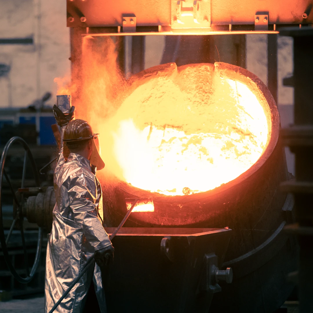 Foundry worker pouring metal