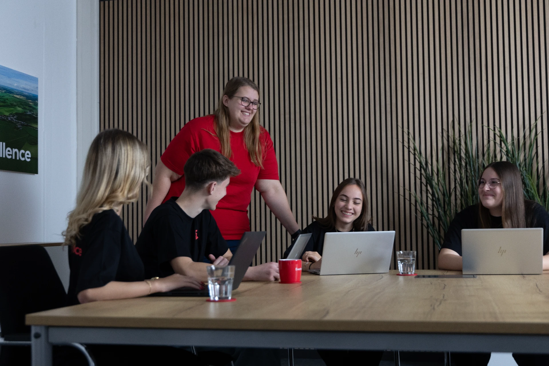 Team diskutiert Projekte und analysiert Daten in einem modernen Besprechungsraum.