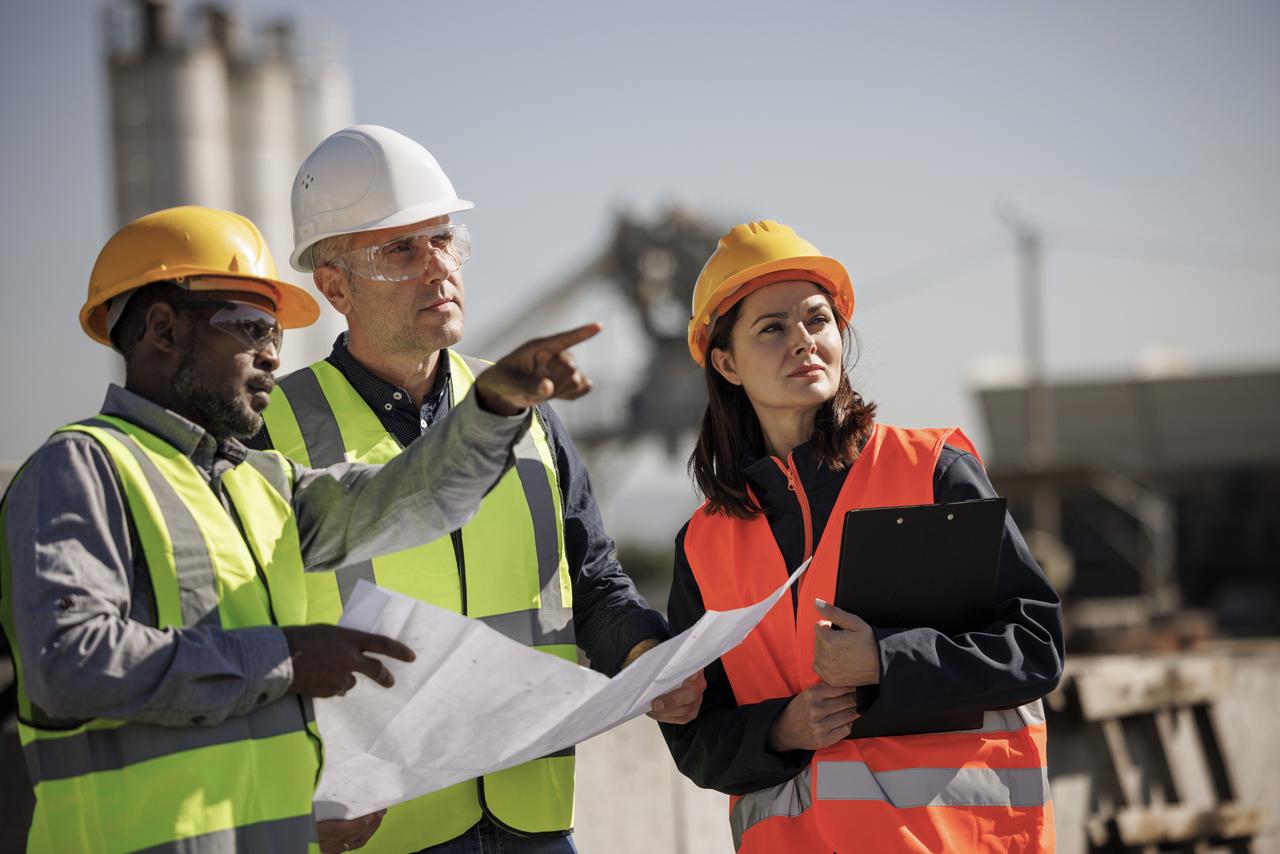 Group of industrial engineers and investor chatting at industrial facility