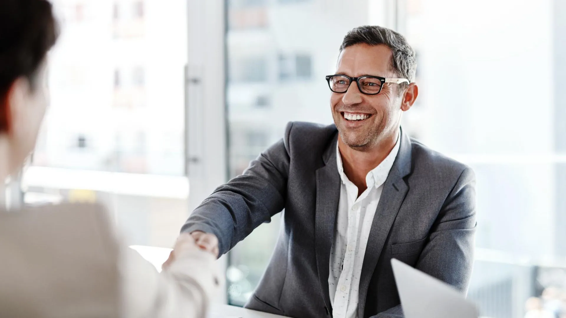 Smiling man in a suit shaking hands