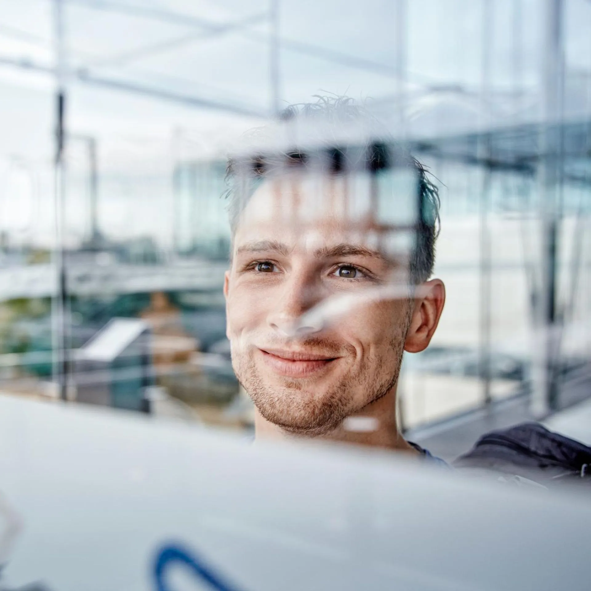 Portrait of smiling young man at the airport looking out of window