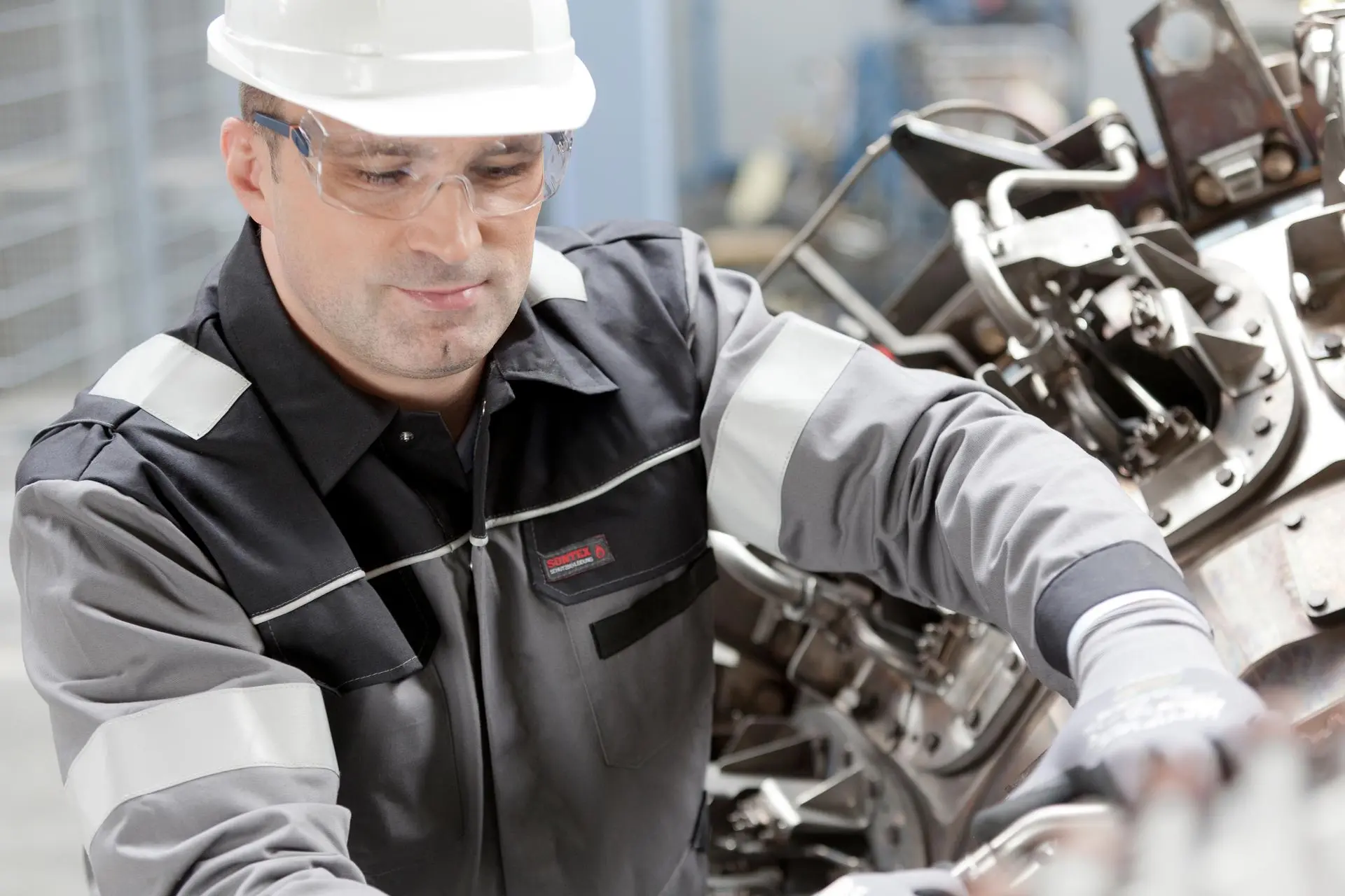 Production worker working on an engine