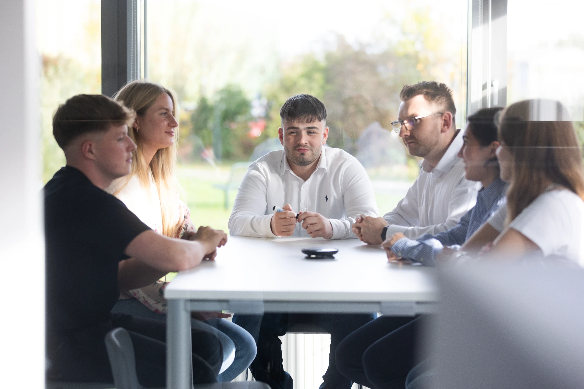 Gruppe von Studierenden arbeitet gemeinsam an einem Projekt und tauscht Ideen aus.