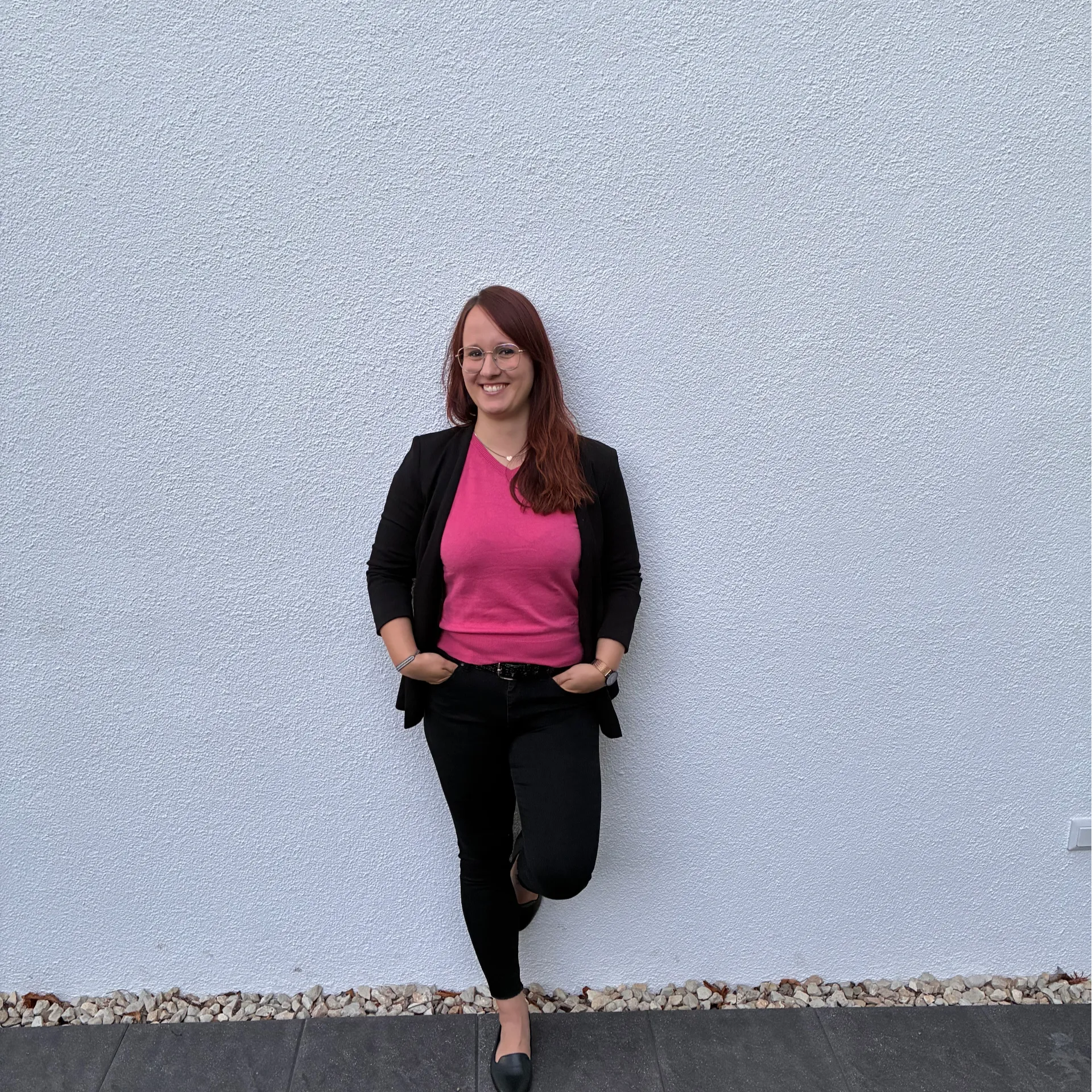 Smiling woman standing infront of a wall