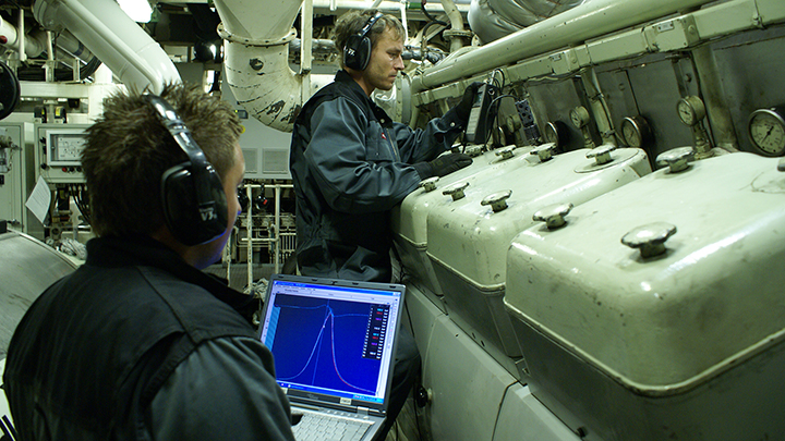two service workers checking an engine