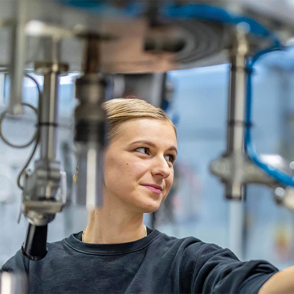 trainee working at a machine in the production
