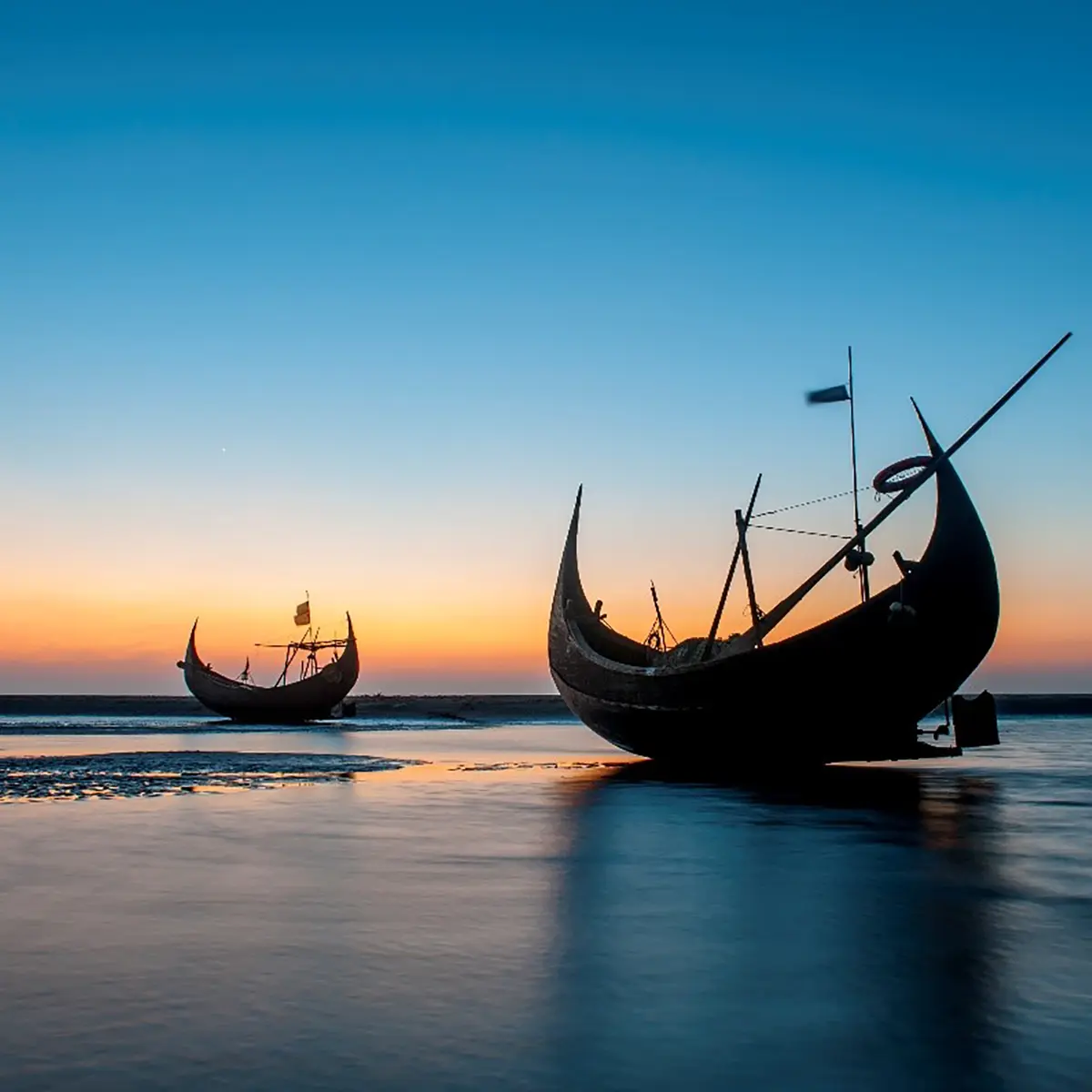 two traditional Bangladesh boats at sunset
