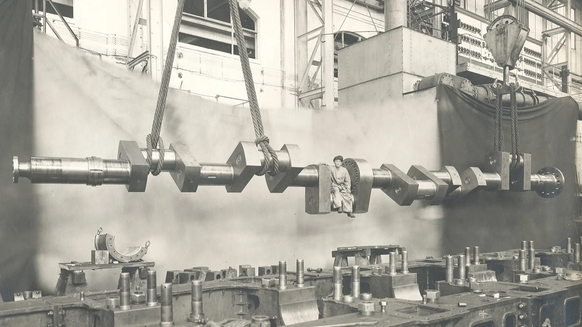 historisches Bild Mann sitzt auf Kurbelwelle