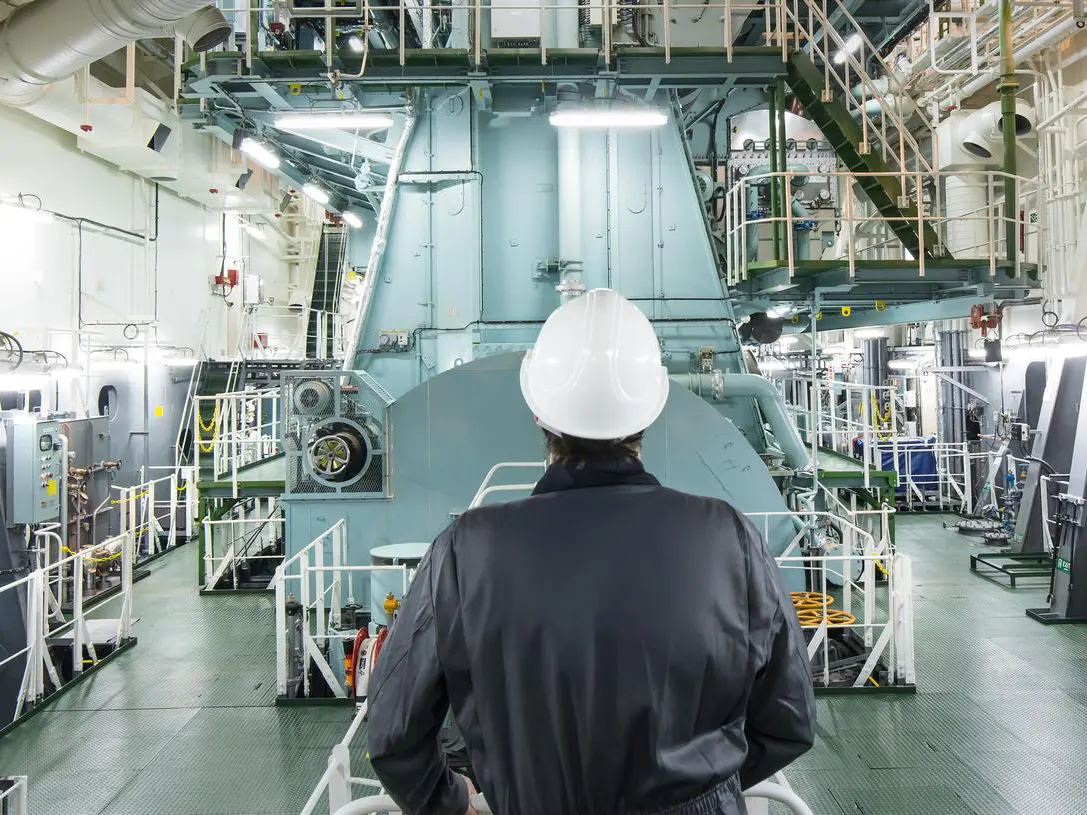 employee at a ship looking at the eninge in the engine room