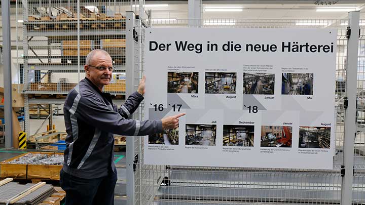 production worker showing at a poster on the new hardening shop