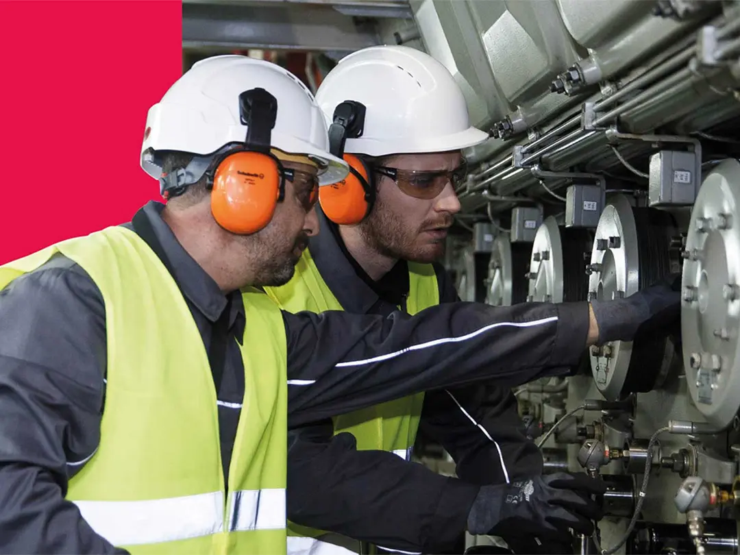 two service employees inspecting a marine engine