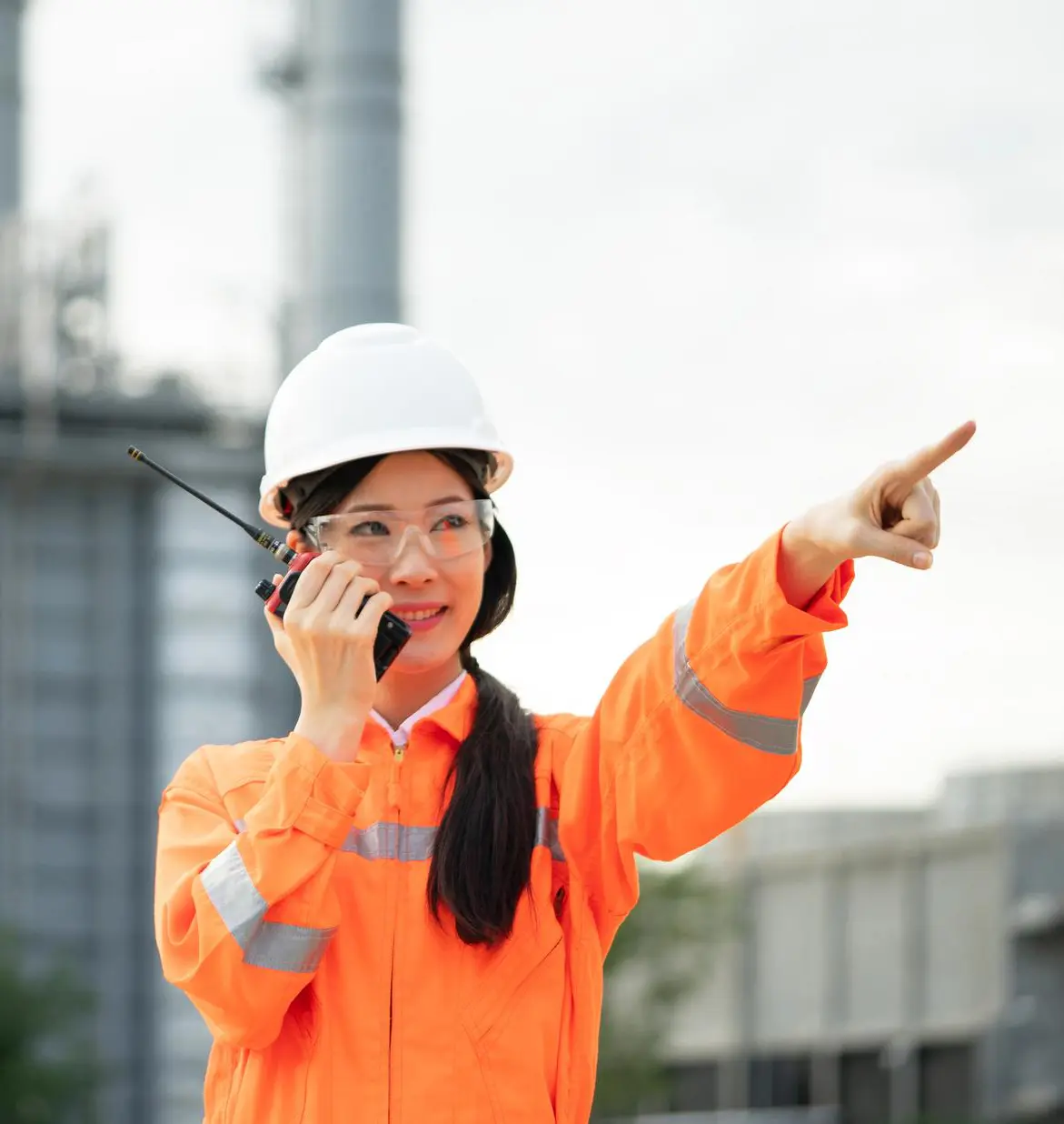woman in safety jacket talking into a walkie-talkie
