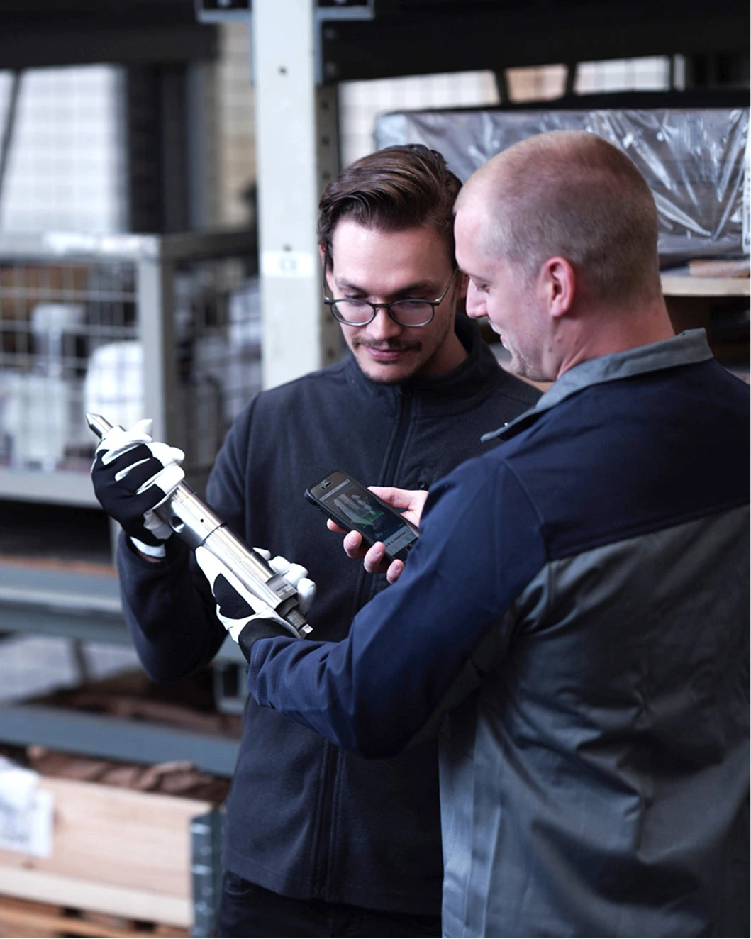 two engineers inspecting a spare part with technology
