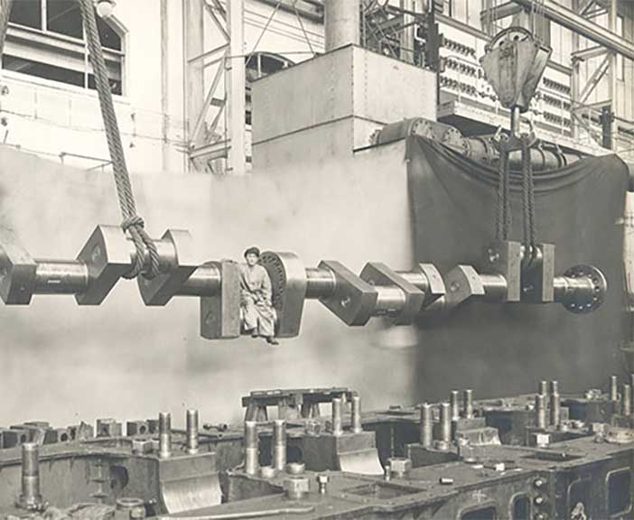 worker sitting on a huge crank case