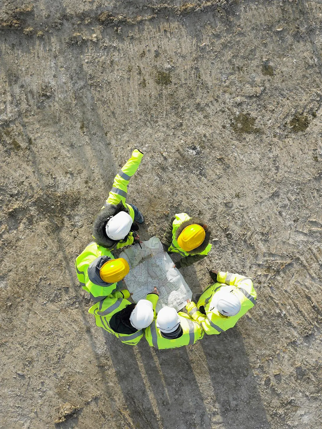 arial view of a group of people in saftey jackets looking at a map