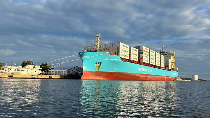 Laura Maersk vessel docked at the port under a cloudy, dark sky