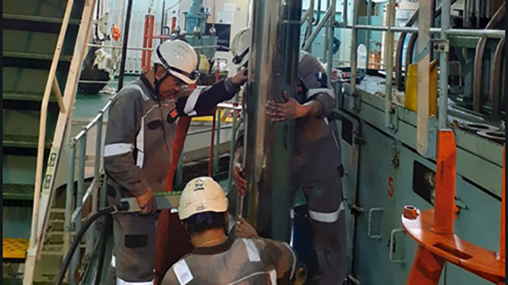 service employees working in the machine room of a ship