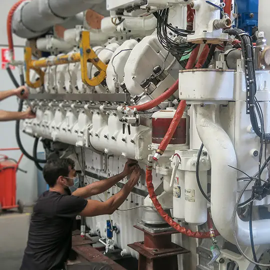 two service employees working at an engine