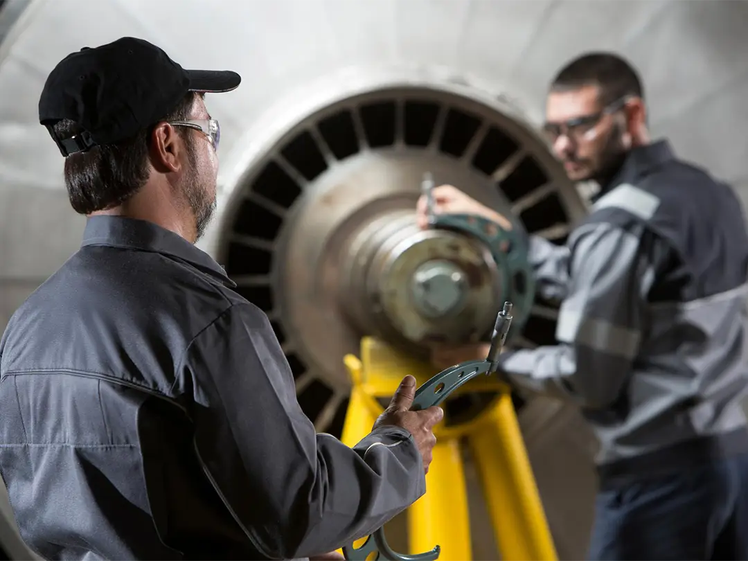 two service employees working at a turbine