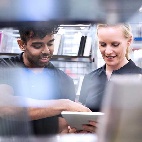two employees looking at a tablet
