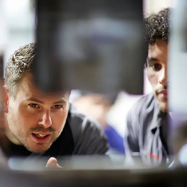 close up of service employees looking at an engine