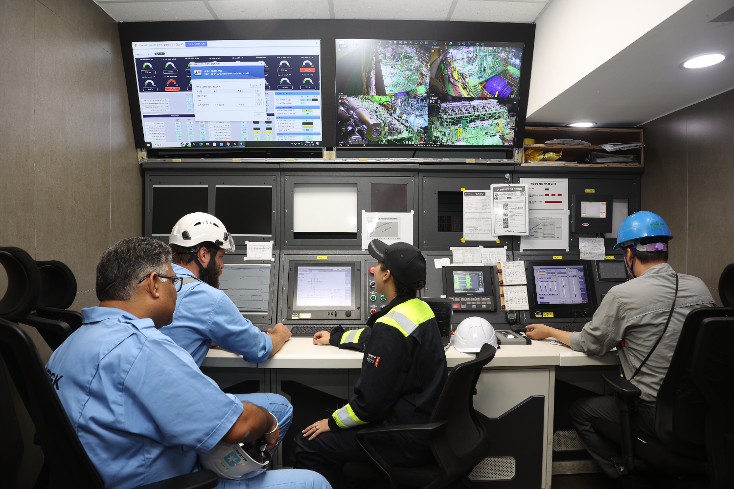Several engineers seated in a control room monitoring data on multiple screens, overseeing ME-LGIM engine testing operations