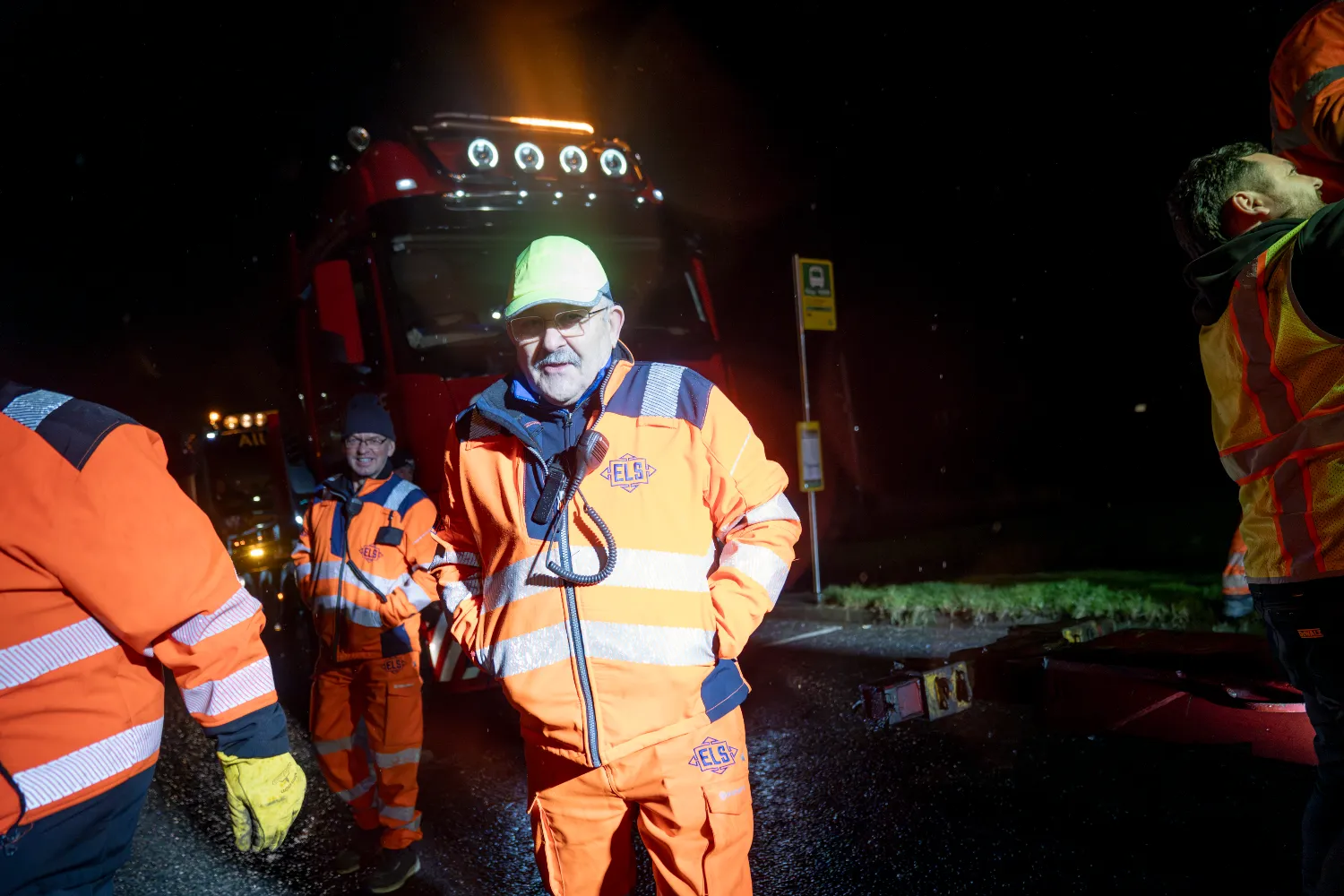 Edwin Sunderland in high-visibility gear leading the transport crew at night.