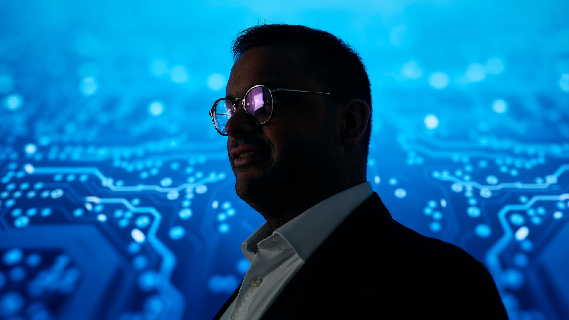 Silhouette of a person viewed in profile against a digital background with connected data points and network visualizations.
