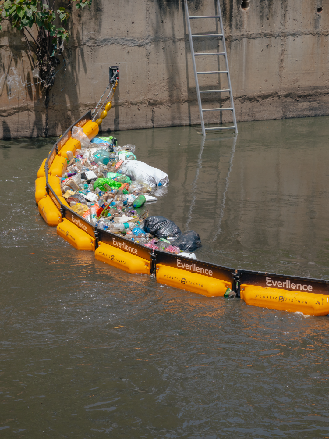 Plastic Fischer’s floating TrashBoom intercepting plastic waste in a canal in Bengaluru, India.