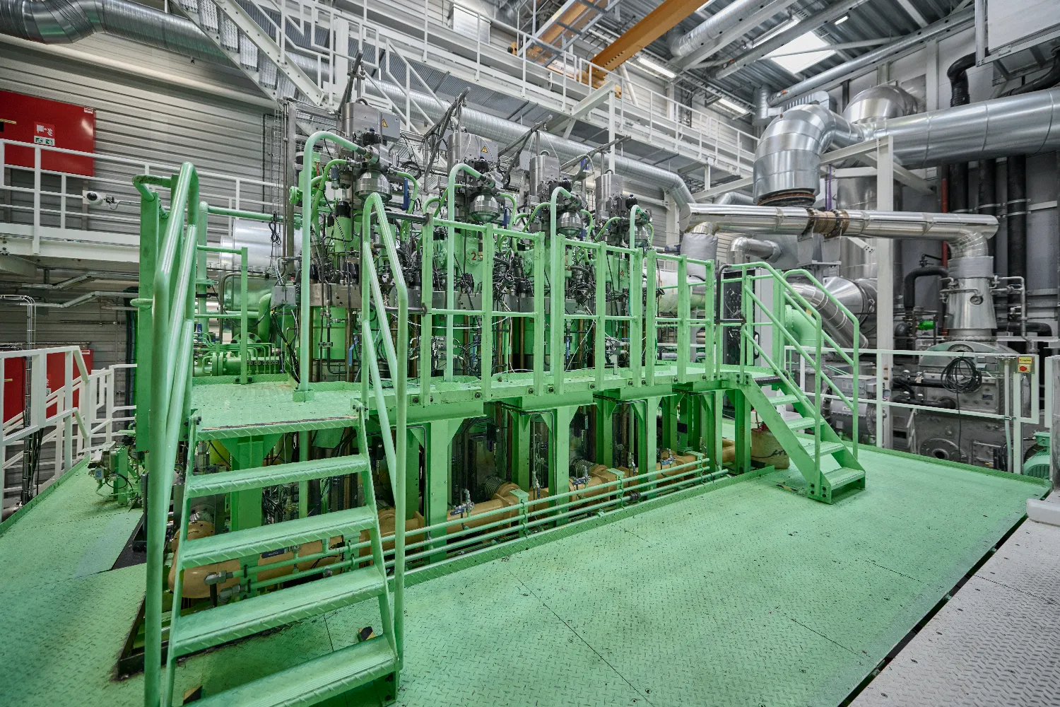 Large-scale ammonia dual-fuel two-stroke test engine with pipes and control units at Everllence’s RCC in Copenhagen.
