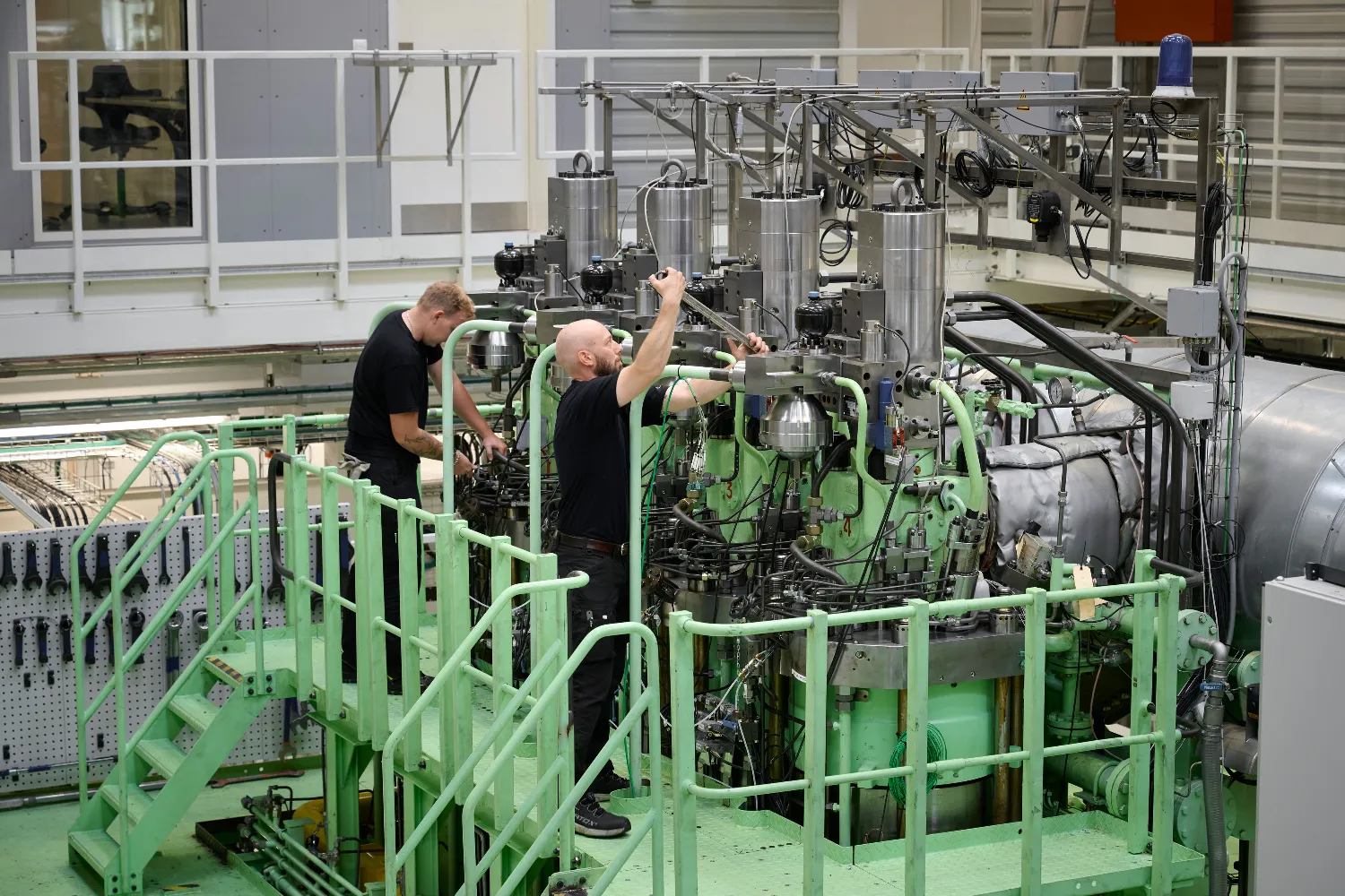 Engineers at Everllence inspect and work on a dual-fuel two-stroke engine designed to run on synthetic fuels such as green methanol and ammonia.
