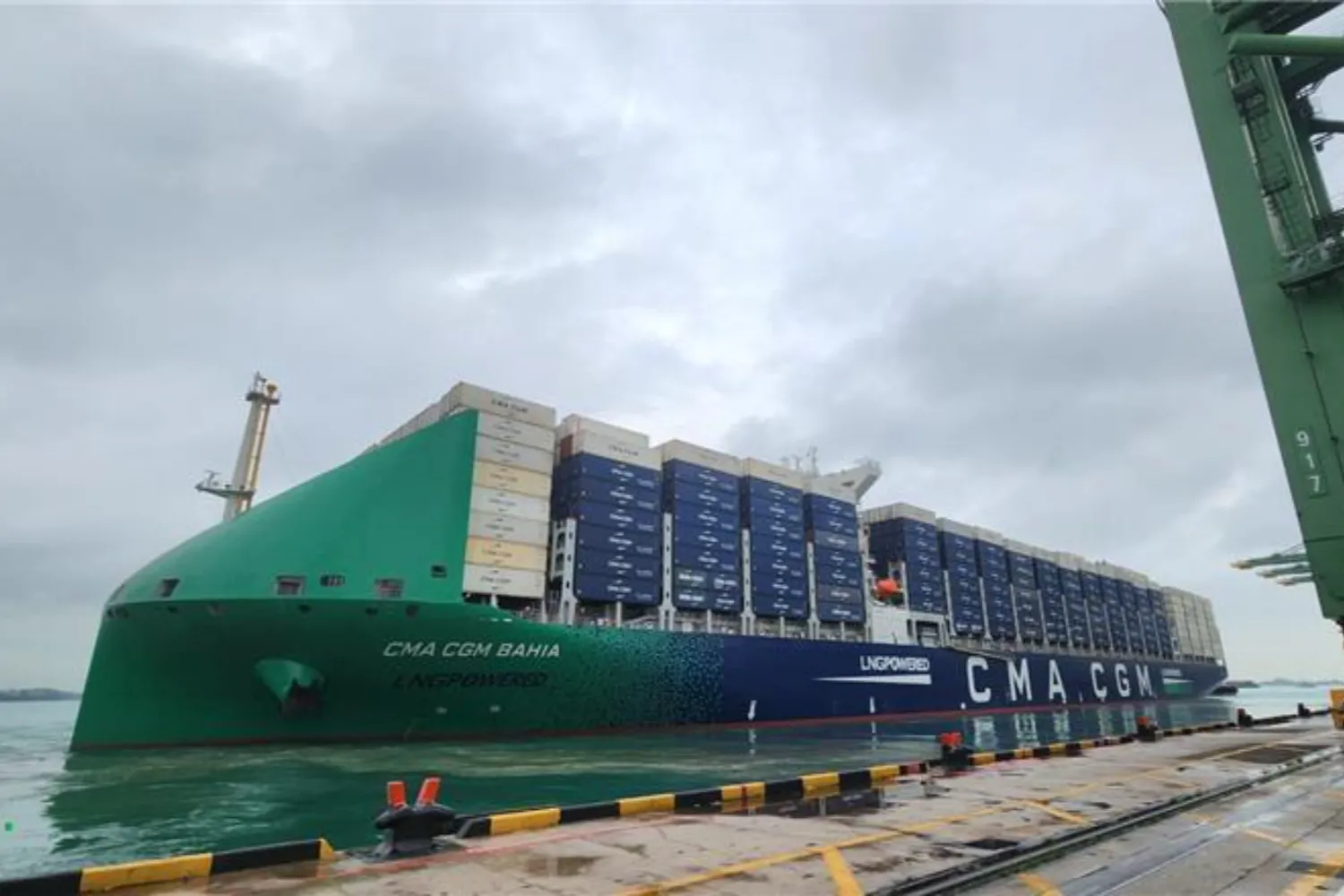 The CMA CGM Bahia, a large LNG-powered container vessel, docked at port and loaded with cargo containers, representing low-emission maritime transport.