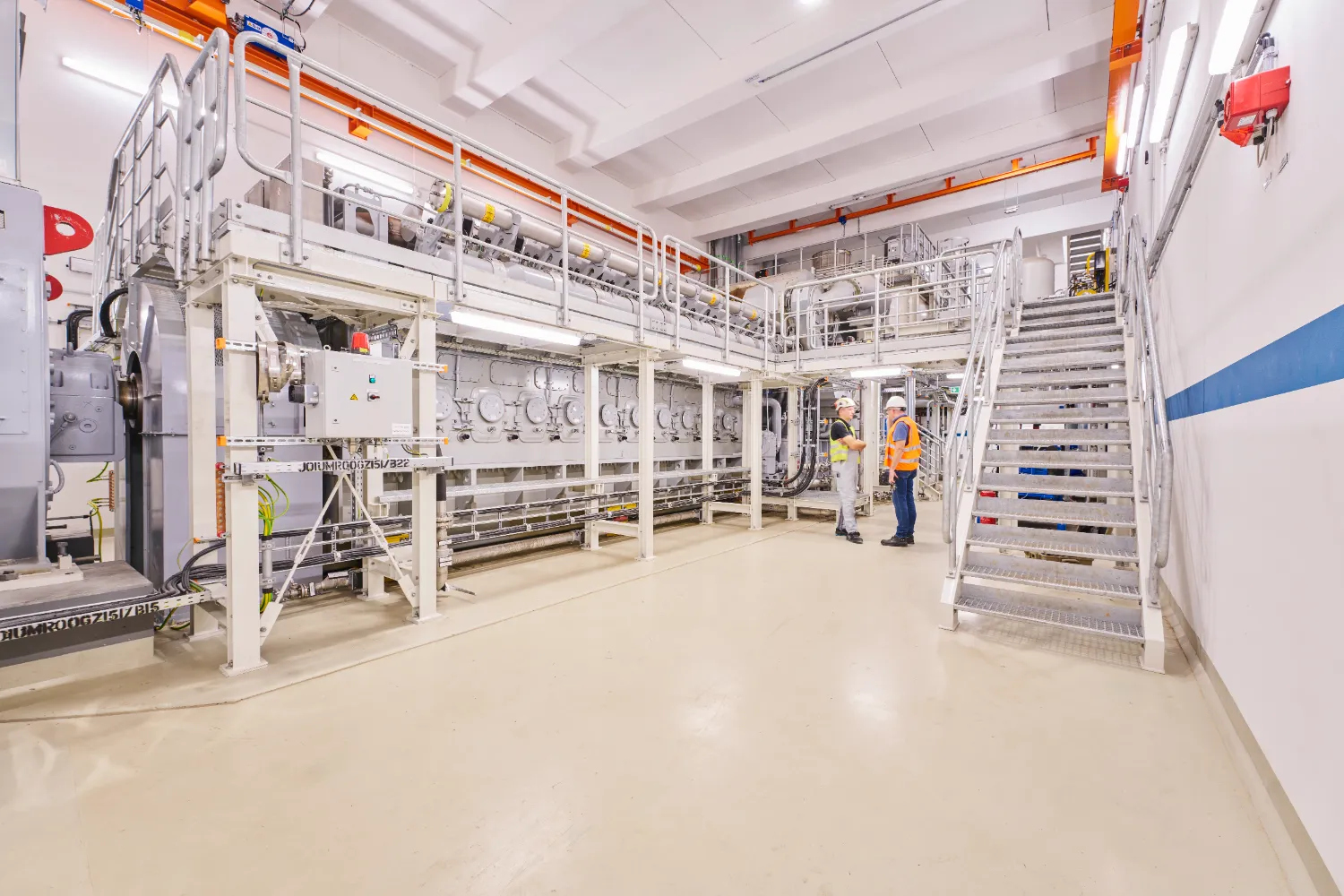 A clean and brightly lit industrial hall with visible machinery and piping, showing the modern infrastructure of the Chemnitz-Nord CHP plant.