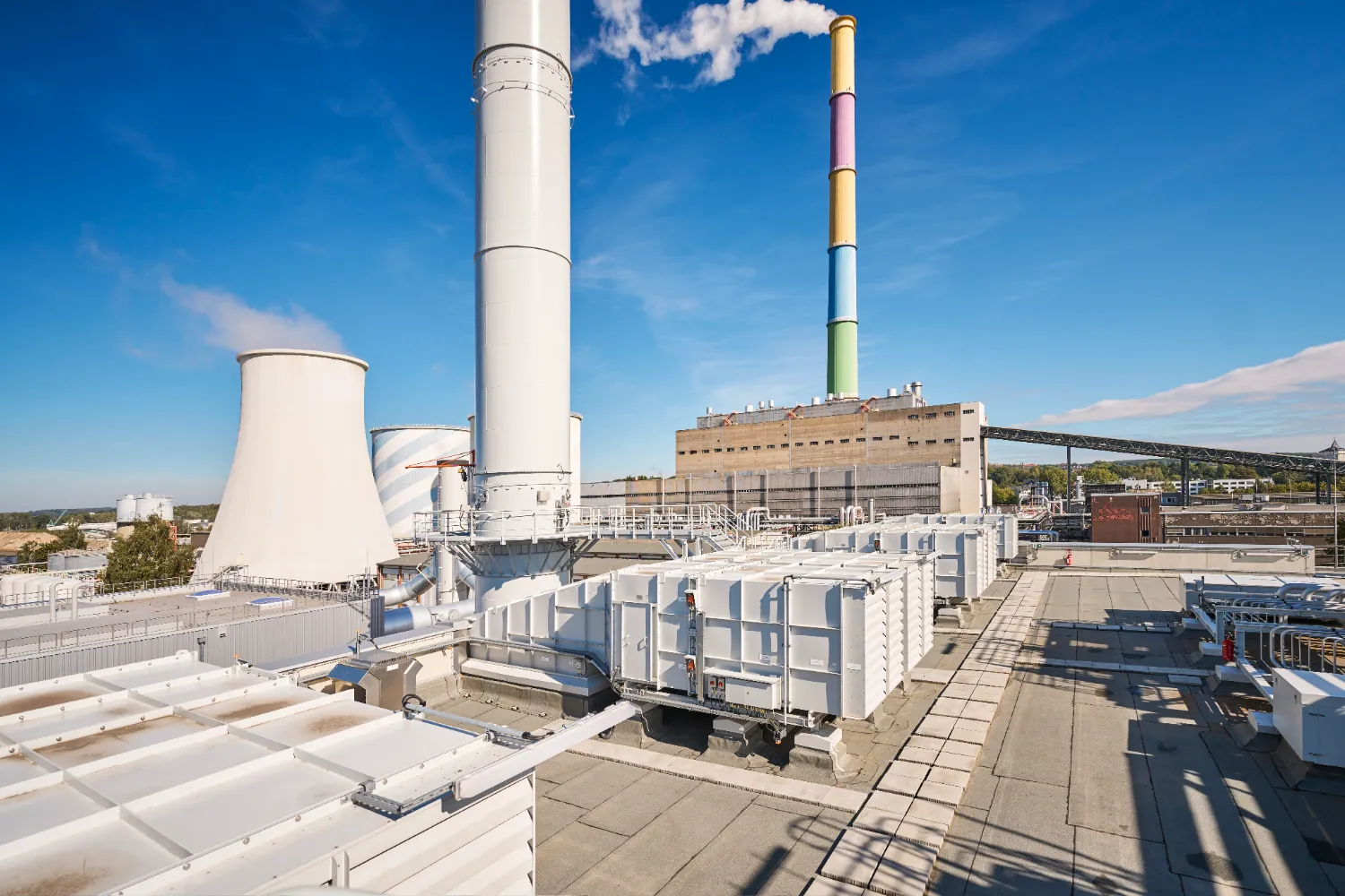 Industrial facility with multiple chimneys, including the iconic rainbow-colored Lulatsch stack, marking the transition from coal to gas-powered energy in Chemnitz.
