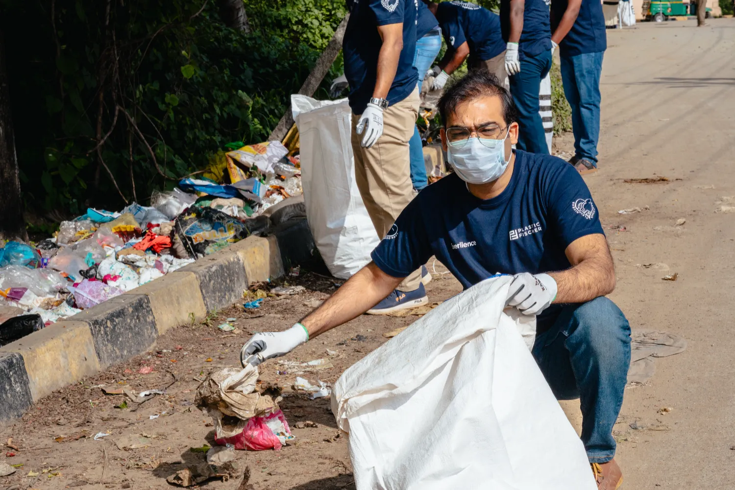 Everllence employee picking up plastic waste during a clean-up near Jigani