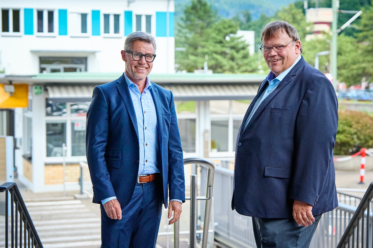 Two people standing in front of the Gernsbach paper mill building.