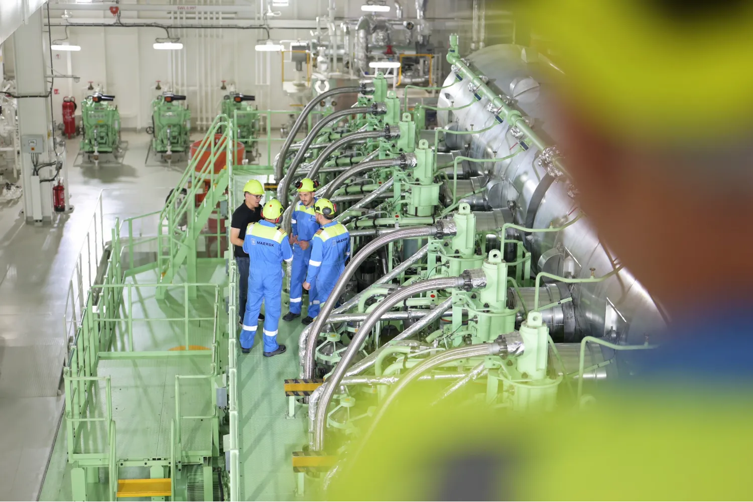 Engineers and crew gather around the Everllence G95ME-C10.5-LGIM engine aboard the Antonia Mærsk, spanning multiple floors.