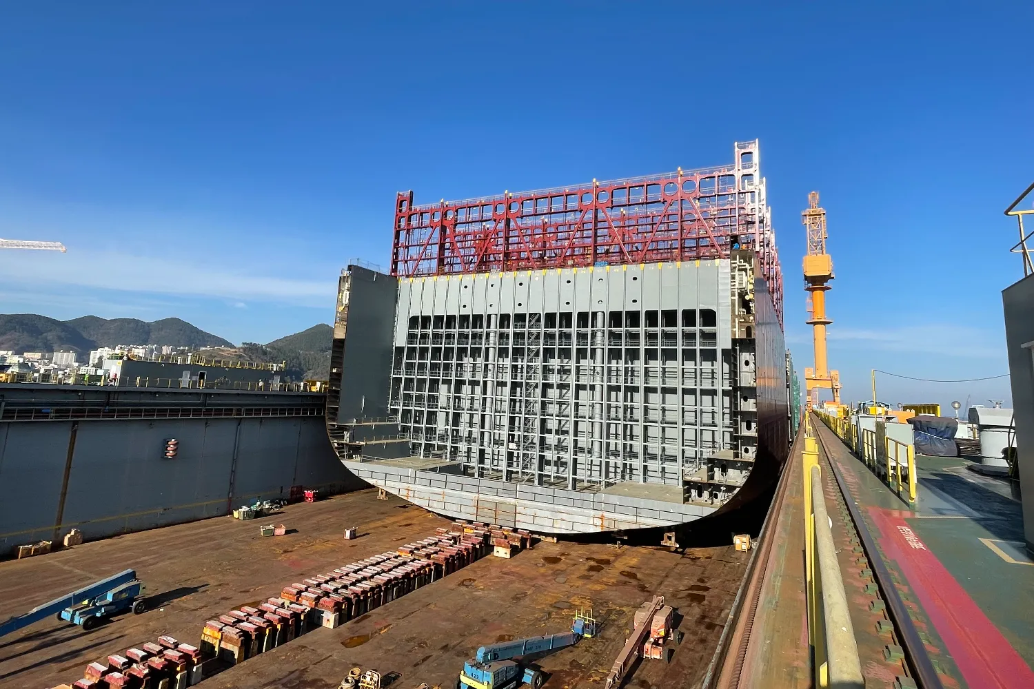 A large ship section being positioned in the dry dock during the keel laying of the Hamburg Express at Hanwha Ocean Shipyard in Okpo, South Korea.