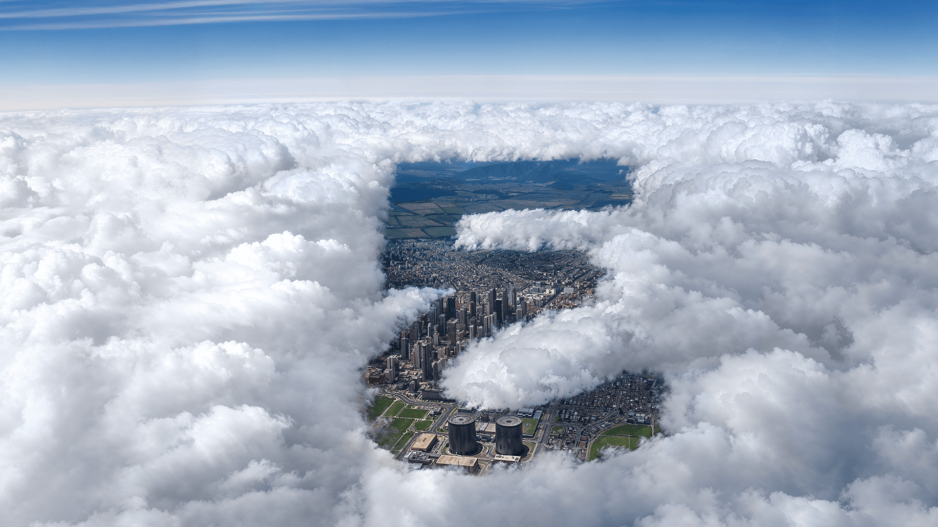 Everllence Supersign als Loch in einer dichten Wolkendecke, wodurch man Hochhäuser einer Stadt sieht