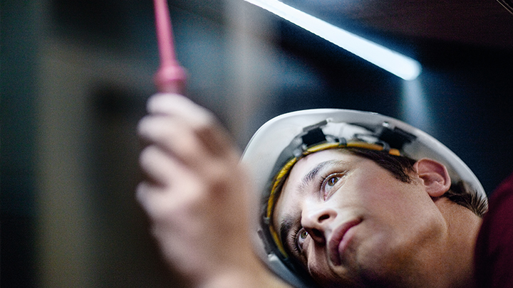 Maintenance Made Easy Service technician in safety gear performing inspection under LED lighting