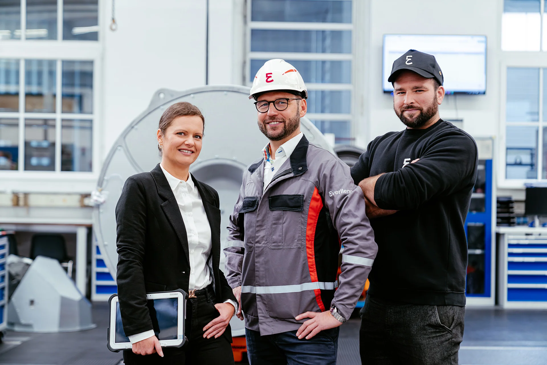 Three Everllence experts standing together in a workshop