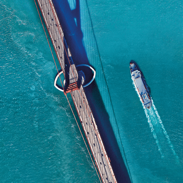 Ferry sailing next to a bridge
