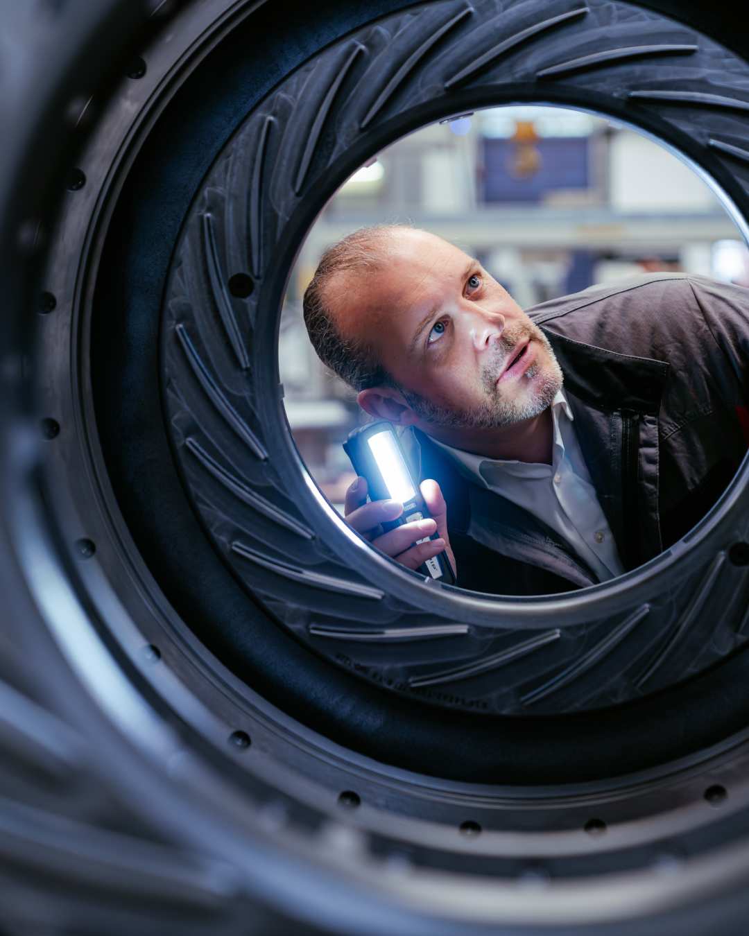 Engineer inspecting a turbine component with a handheld light
