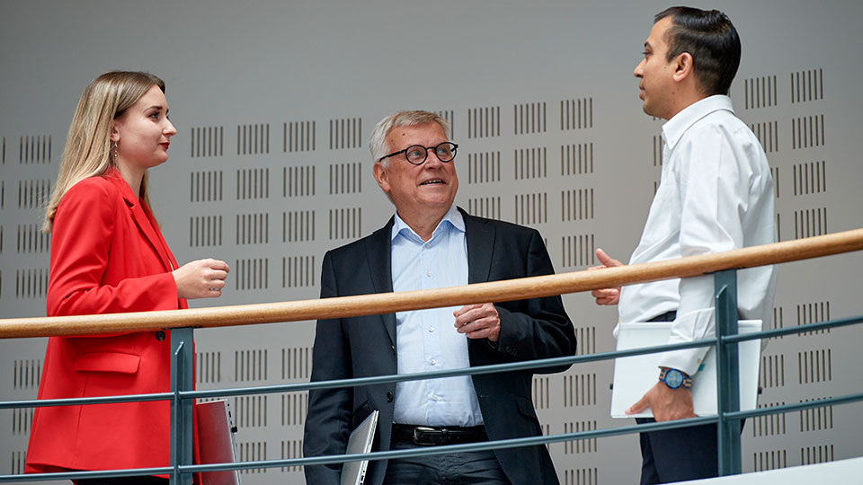 A women and two men are talking with each other