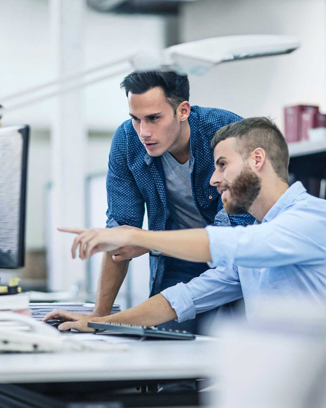 Two man looking together at a screen