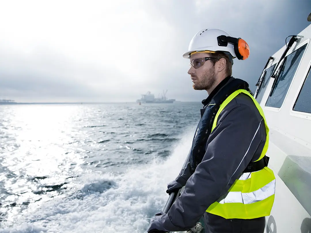 Employee on a ship looks into the water