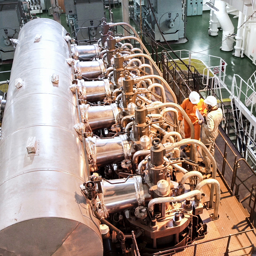 Engine room with MAN B&W two-stroke engine and engineers