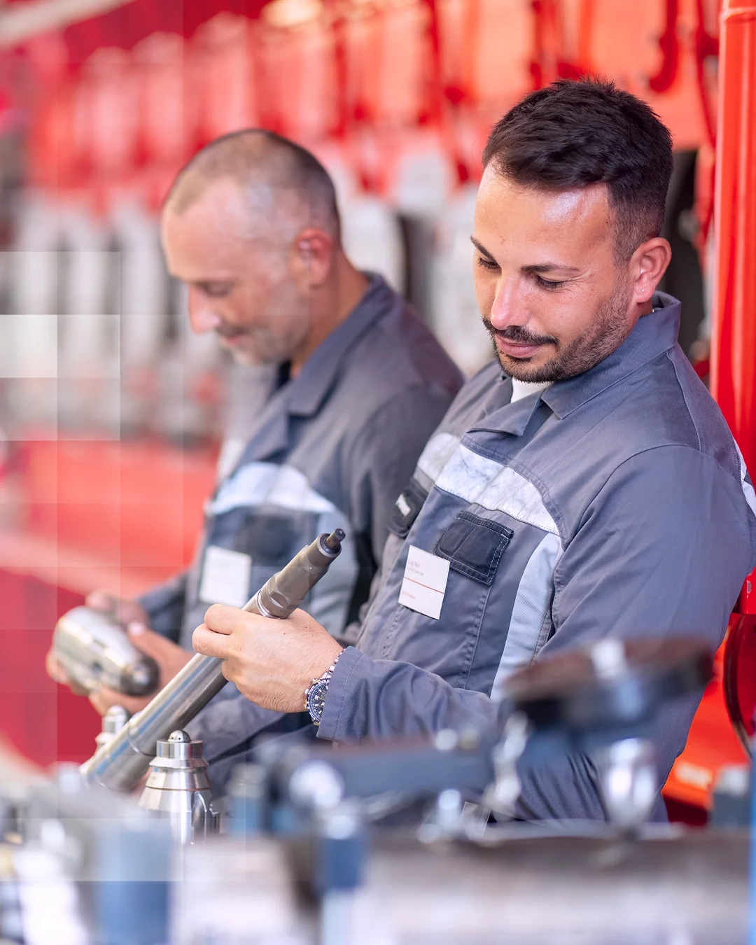 Two technicians inspecting a component in a workshop