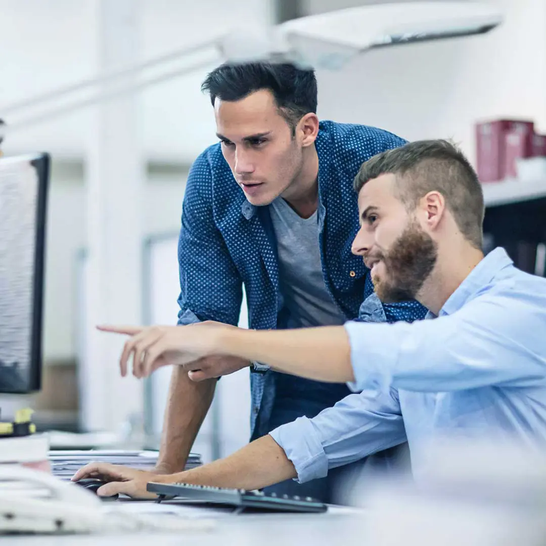 two office employees looking at a screen