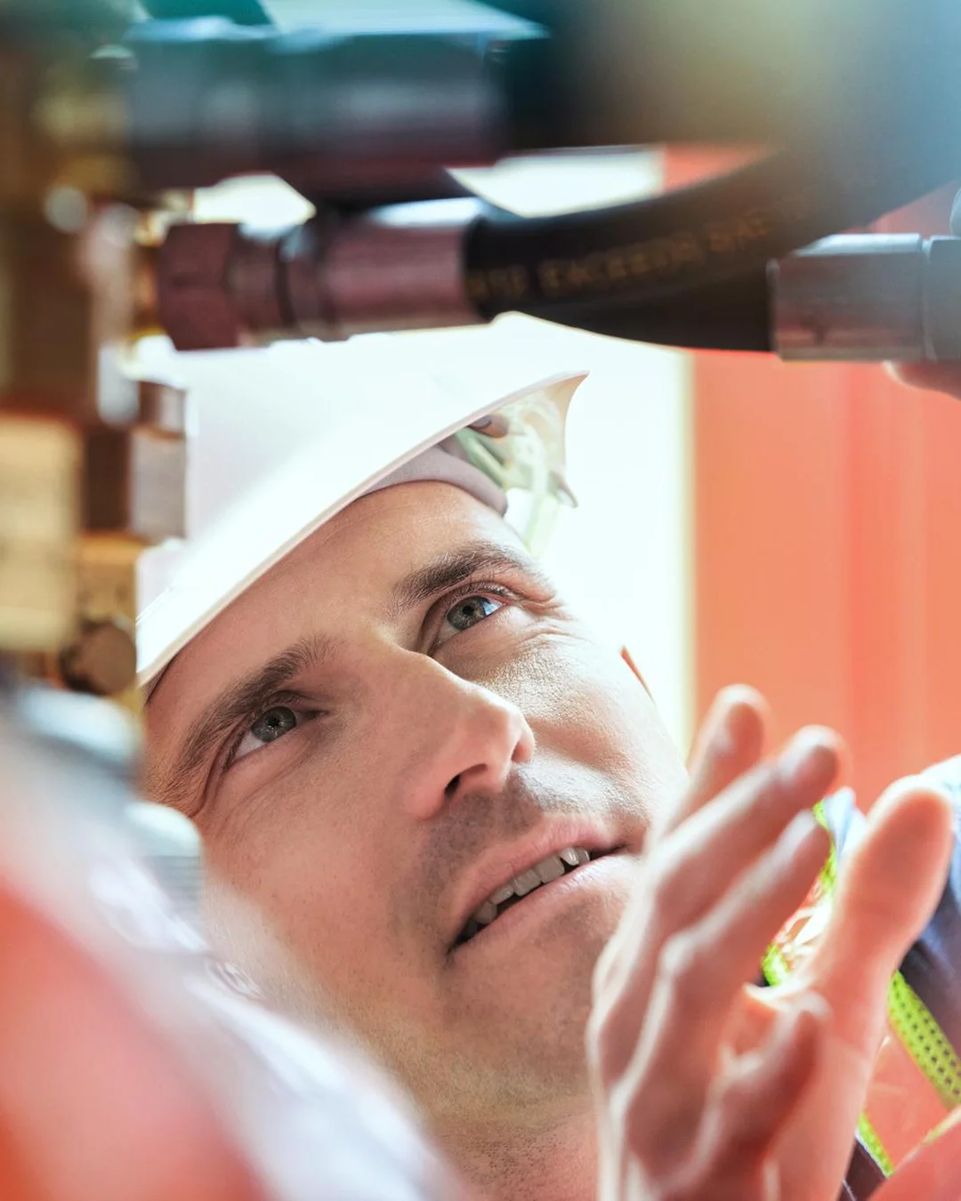 Man wearing a safety helmet inspecting pipes and fittings